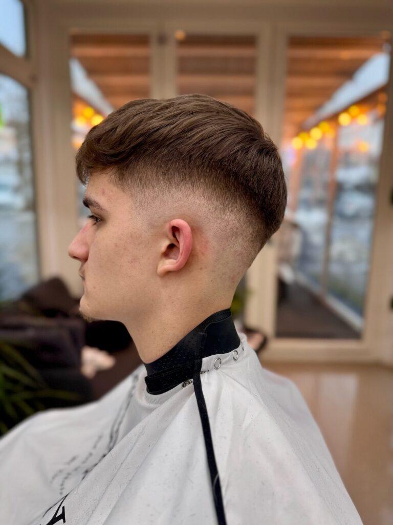 Mid fade hajvágás hosszabb, texturált felsővel, oldalnézetből